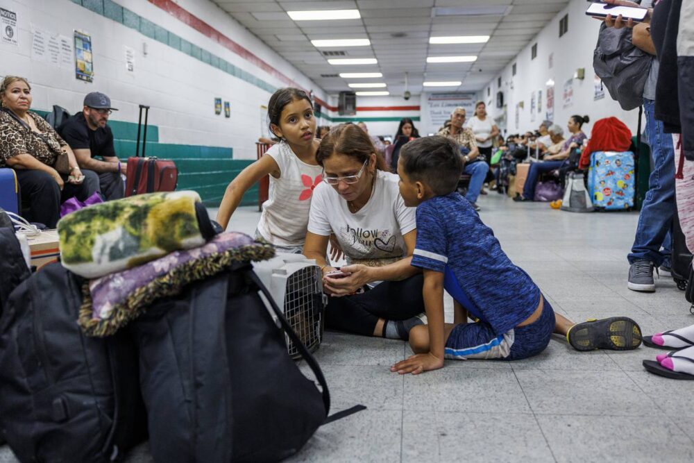 Yuledy and Pedro surround their mother Esperanza as they sit on the floor of the the Los Limousines bus station before taking an 11-hour bus ride to Denver on July 13, 2023 in El Paso, Texas. The Venezuelan family had recently entered the United States from Mexico.