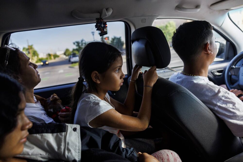 Yuledy rides on her mother's lap while siting next to Yolexi as they are driven from the Los Limousines bus station by Owen Ceballos to the Denver Coliseum on July 14, 2023, in Denver. 