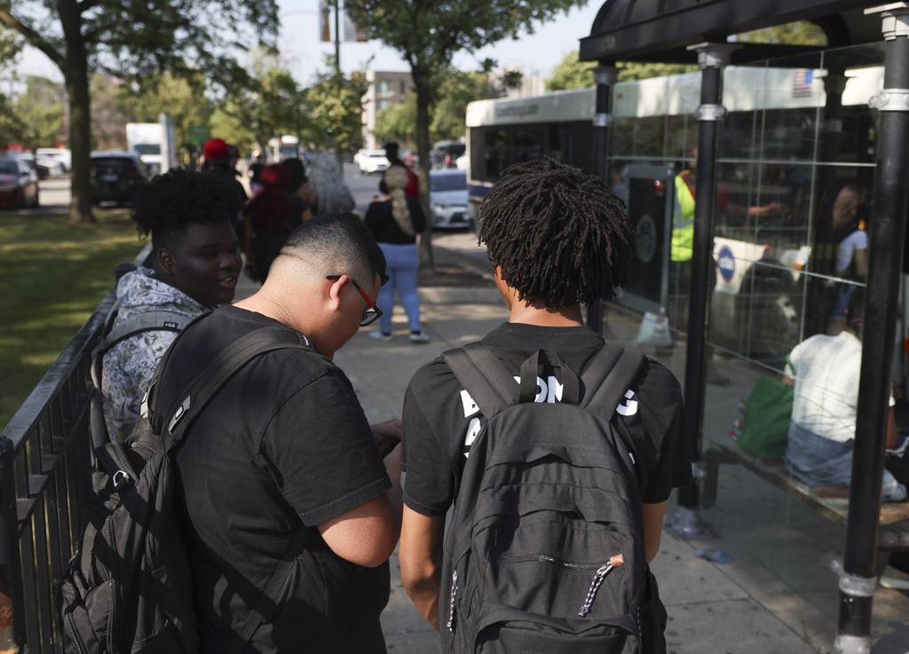 Young people wait for a bus across the street from Roberto Clemente Community Academy in Ukrainian Village after school on Aug. 24, 2023. 