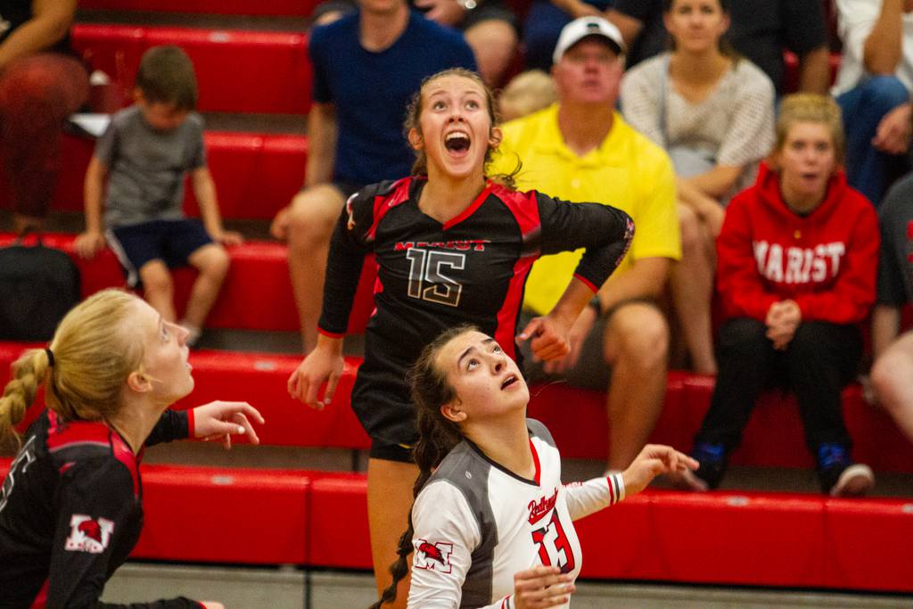 Marist's Bella Bullington (15) and Briana Hill (13) react during a volley against Marian Catholic in an East Suburban Catholic Conference match in Chicago on Tuesday, Sept. 6, 2022.