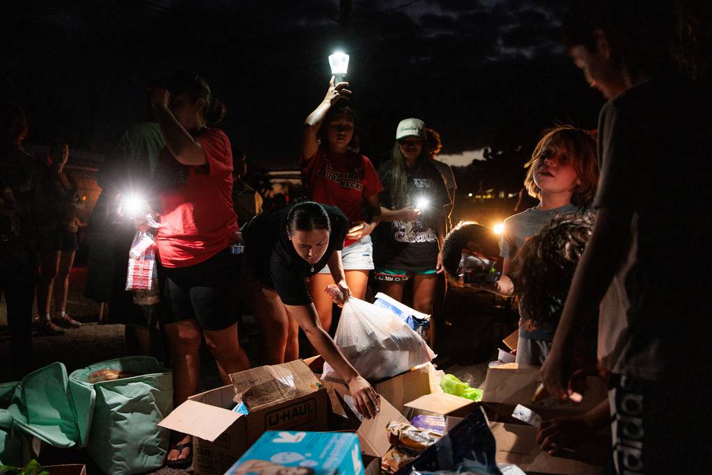 Residents collect food and other supplies delivered by volunteers in Olowalu, Maui, Hawaii, Aug. 12, 2023. 