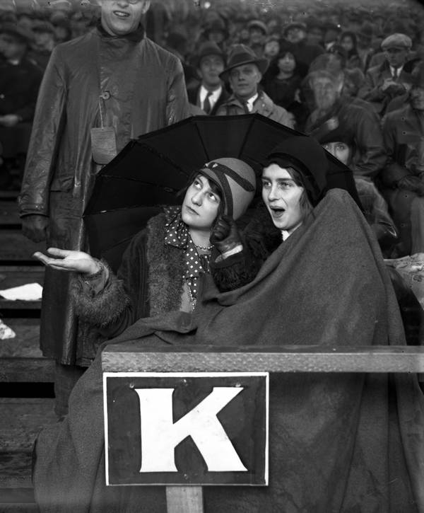 Edna Waldvogel and Merritt Jennings watch a football game in the rain and cold at Stagg Field, circa 1928.