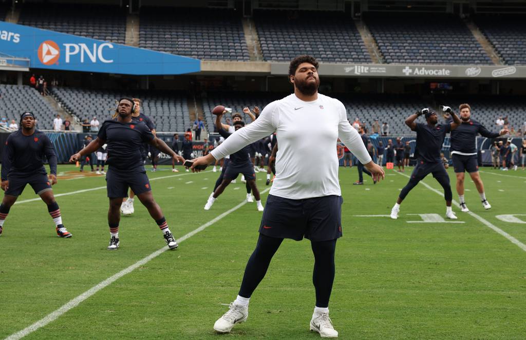 Bears offensive tackle Darnell Wright stretches with teammates before a preseason game against the Titans at Soldier Field on Aug. 12, 2023.
