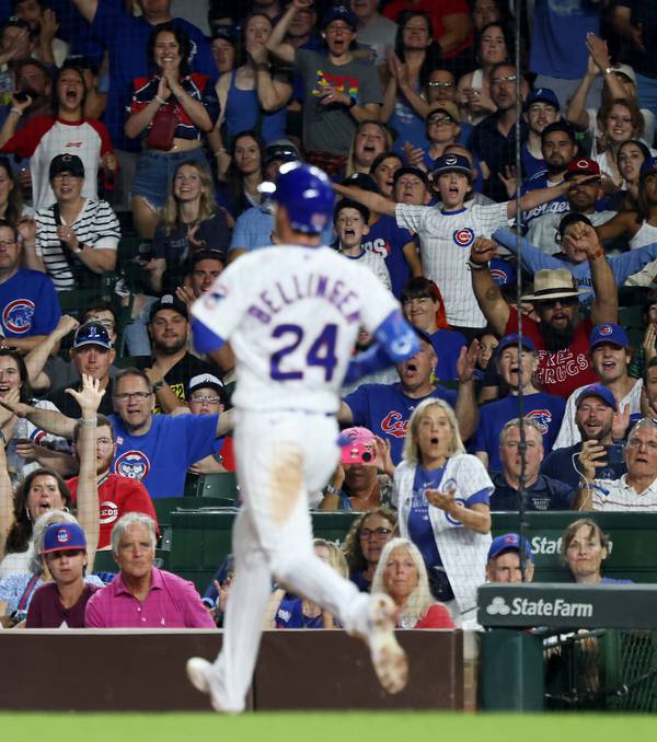 Cubs fans gesture and celebrate as Cody Bellinger reaches for a single in the seventh inning against the Reds at Wrigley Field on Aug. 2, 2023.