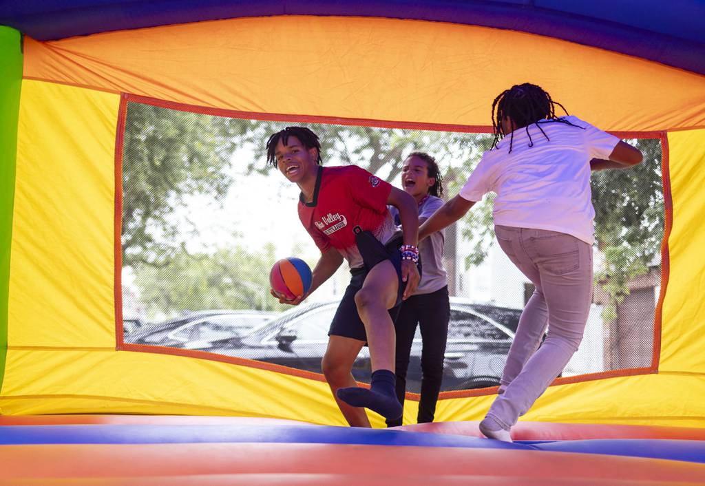 Paris Head plays in a bounce house with other kids during a block party Sunday, Aug. 13, 2023, in West Humboldt Park.