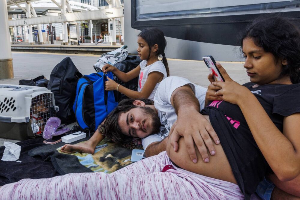 Fabian rubs Yolexi's pregnant belly while waiting at a Denver station for a train that would take the family to Chicago. The family had arrived in Denver earlier in the day after taking an 11-hour bus ride from El Paso, Texas. 