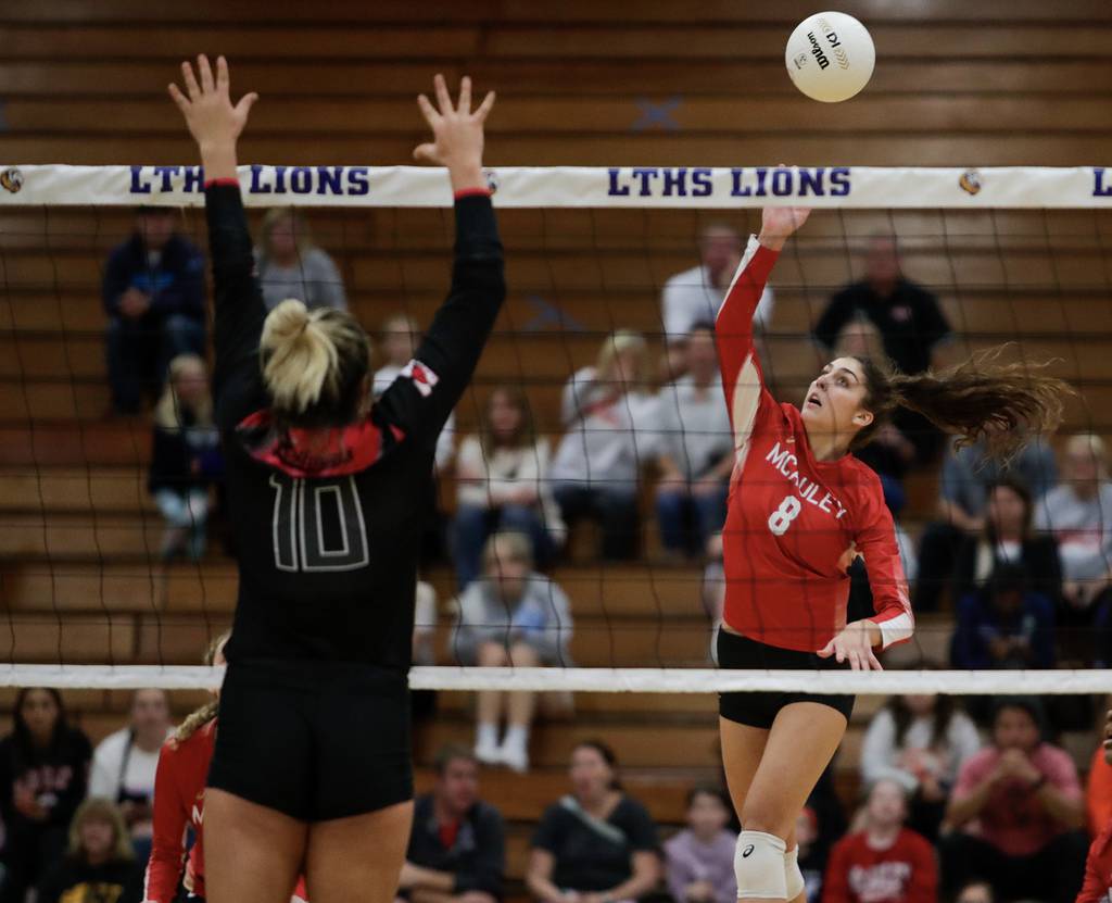 Mother McAuley’s Ellie White (8) goes up for a kill against Marist’s Jessica Kurpeikis (10) during the Class 4A Lyons Sectional championship match in La Grange on Wednesday, Nov. 2, 2022.