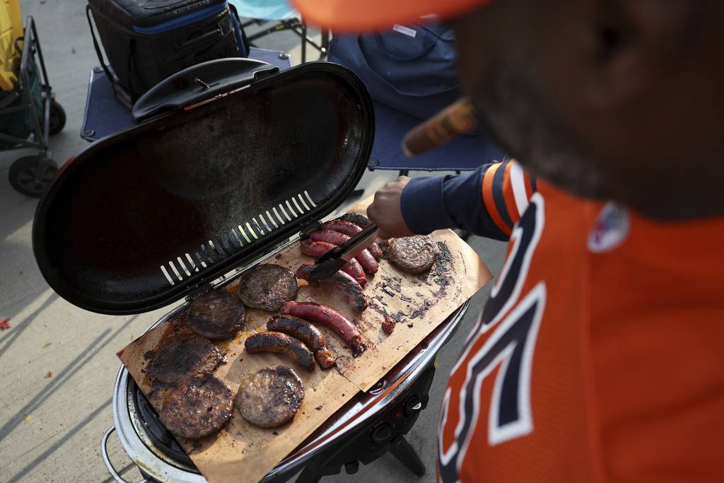 Phil Weeks grills burgers and sausages while tailgating with friends before a game between the Chicago Bears and Washington Commanders at Soldier Field on Oct. 13, 2022.