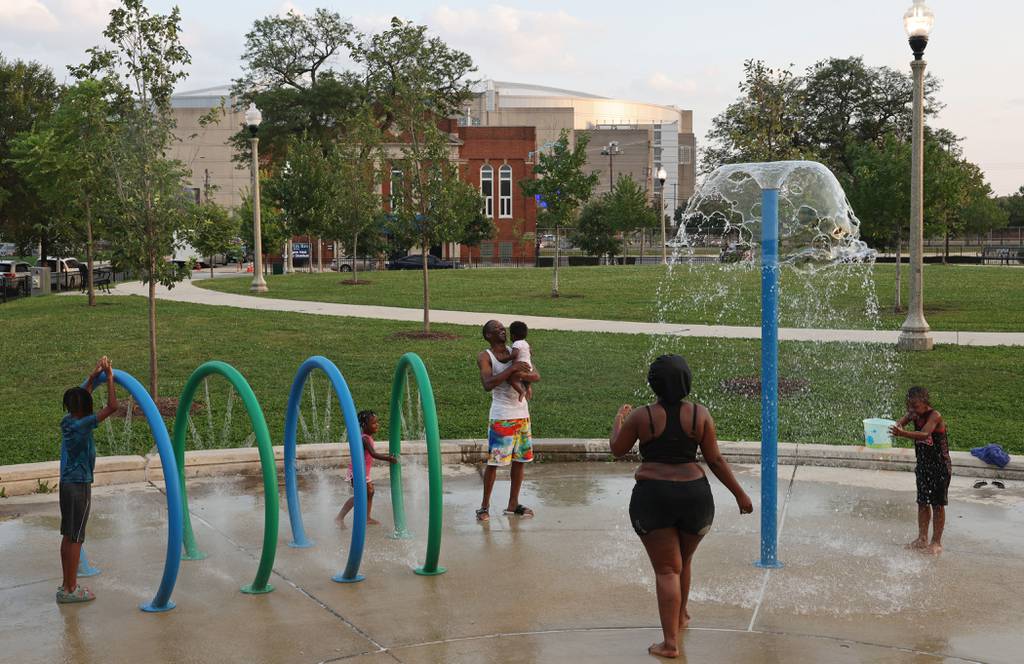 Children and adults play at Park No. 578 in the 1900 block of West Maypole Avenue near the United Center, background, on Aug. 24, 2023, in Chicago.  