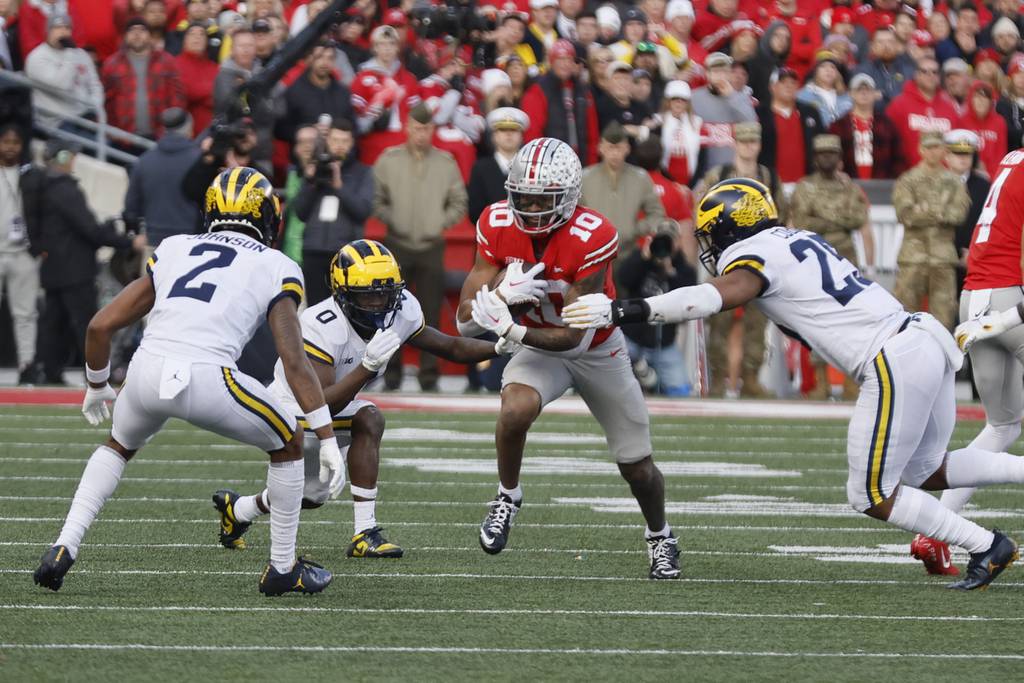 Ohio State receiver Xavier Johnson tries to run between Michigan defenders during the second half of a game on Nov. 26, 2022.