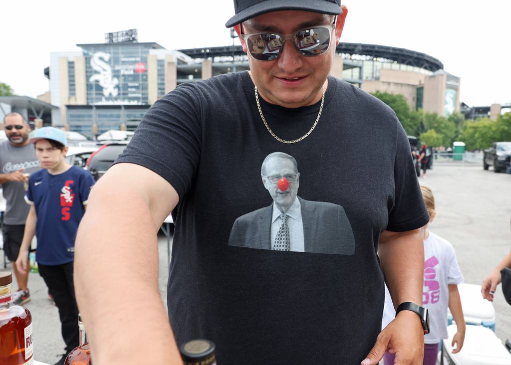 White Sox fan Peter Fonseca prepares for tailgating while wearing a T-shirt with a picture of team Chairman Jerry Reinsdorf with a clown nose before a game against the Athletics on Saturday at Guaranteed Rate Field. 