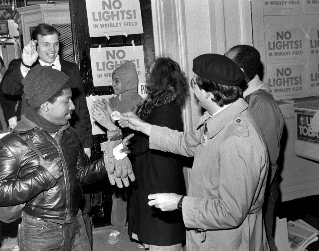Members of Citizens United for Baseball in the Sunshine celebrate Monday's ruling by passing out buttons at the Addison CTA station on March 25, 1985. Judge Richard Curry decided that here will be no lights at Wrigley Field. 