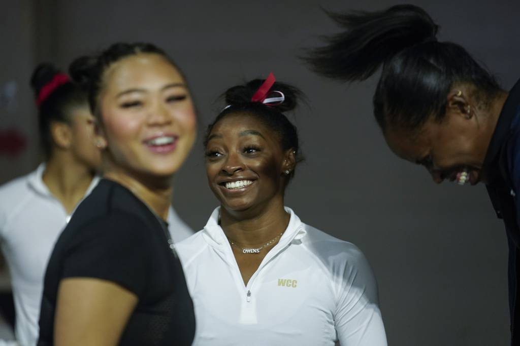 Simone Biles, a seven-time Olympic medalist and the 2016 Olympic champion, center, talks to other gymnasts as she arrive for a practice session at the U.S. Classic gymnastics competition, Aug. 4, 2023, in Hoffman Estates.