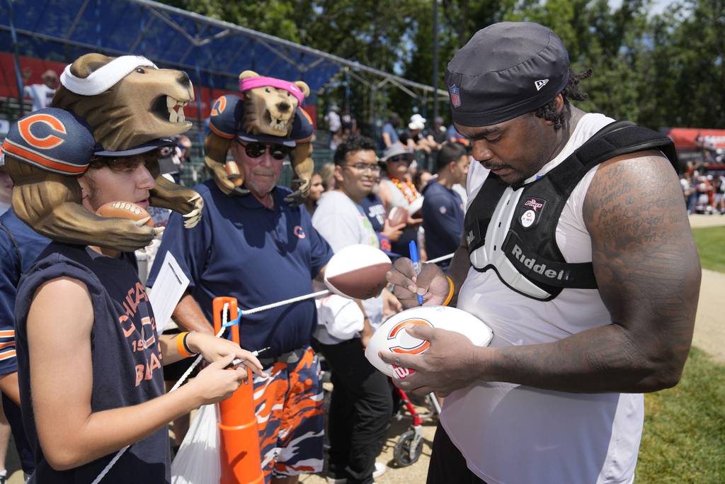 Chicago Bears guard Ja'Tyre Carter signs autographs at the team's Back Together training camp event for fans on July 29, 2023.