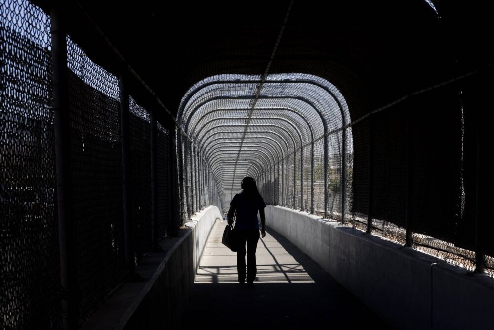 A person passes through a fence-covered bridge that stands between the U.S.-Mexico border at El Paso, Texas, and Ciudad Juárez, Mexico, on July 12, 2023. The Mendez family were told to wait in a little room directly beyond the bridge once they entered the U.S.