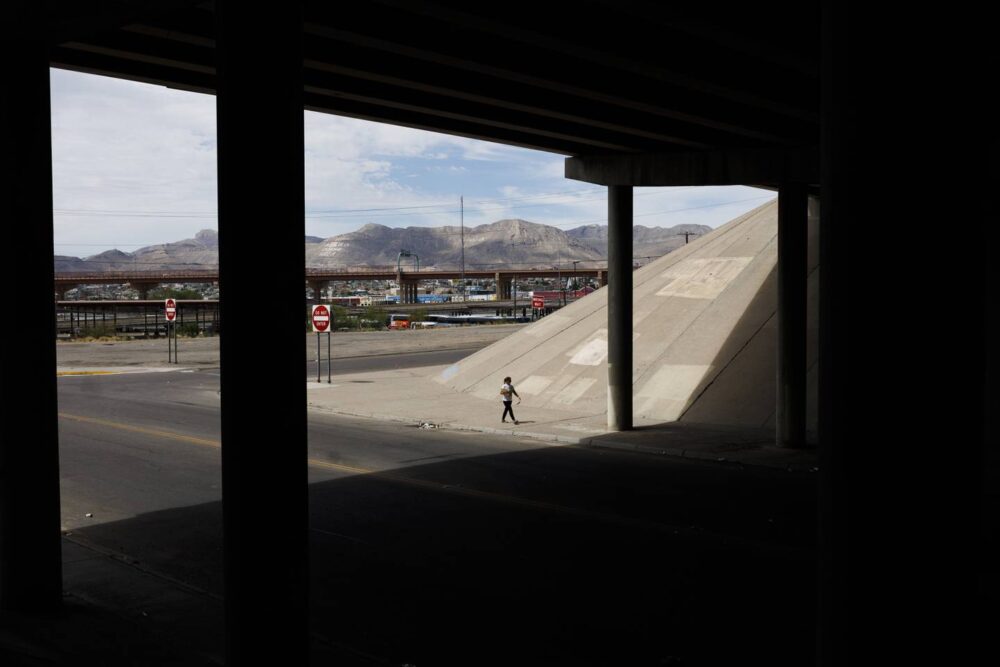 Esperanza walks back to the migrant shelter with Mexico in the distance after the Rev. Jarek Jaroslaw Wysoczanski bought tickets for her and her family to take a bus to Denver later in the day on July 13, 2023, in El Paso, Texas. 