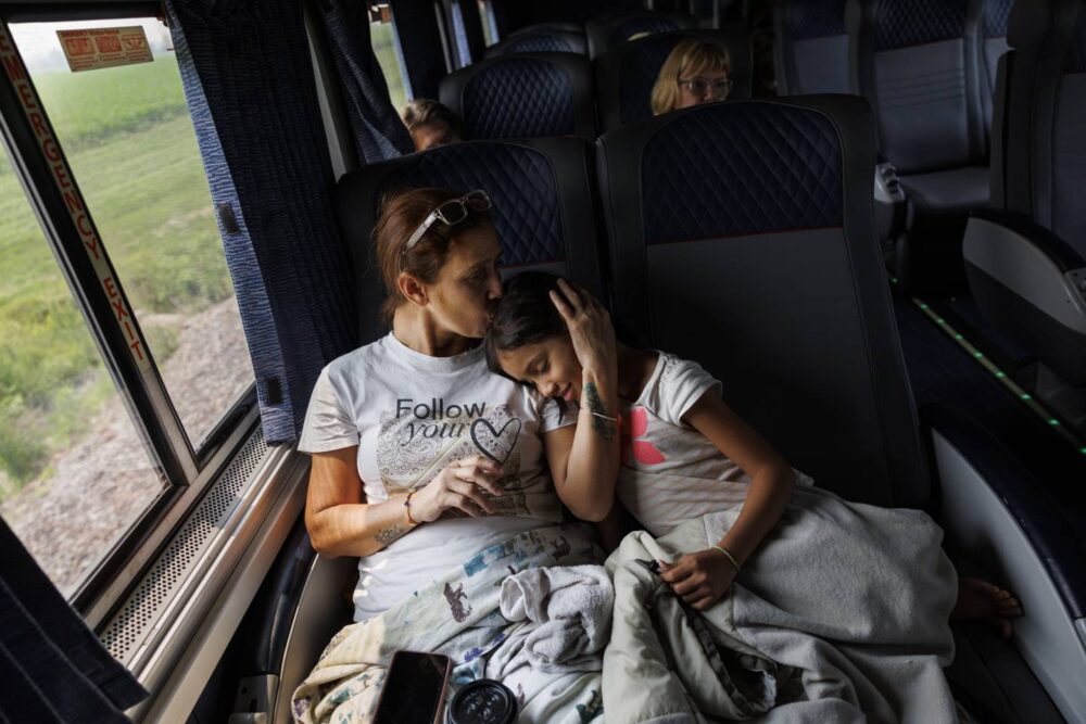 Esperanza kisses Yuledy during their 18-hour train ride to Chicago from Denver on July 15, 2023. The train was roomy compared to the Limousine bus from El Paso.