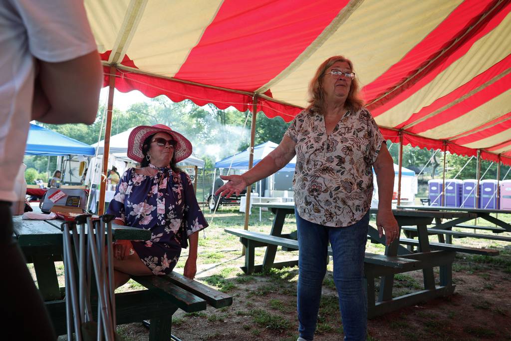 Betty DeFord, right, talks with Debbie Ketter during the Original Redneck Fishing Tournament on Aug. 4, 2023, in Bath. DeFord founded the downstate fundraising fishing tournament in 2005.