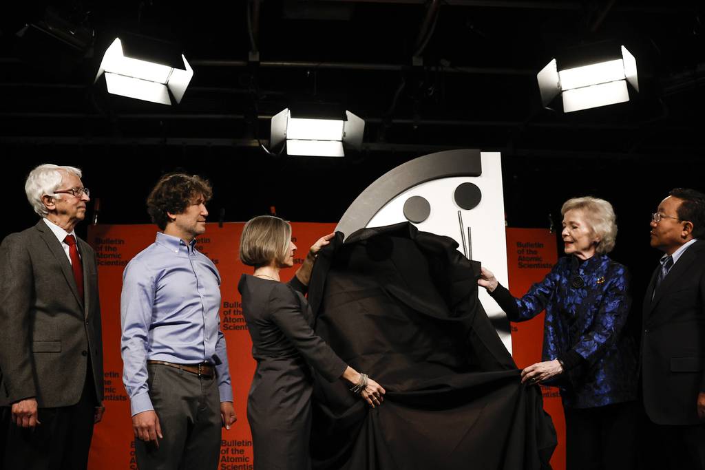 Members of the Bulletin of the Atomic Scientists Siegfried Hecker, from left, Daniel Holz, Sharon Squassoni, Mary Robinson and Elbegorj Tsakhia demonstrate unveiling of the 2023 Doomsday Clock ahead of a livestreamed event on Jan. 24, 2023, in Washington. This year the Doomsday Clock is set at 90 seconds to midnight.