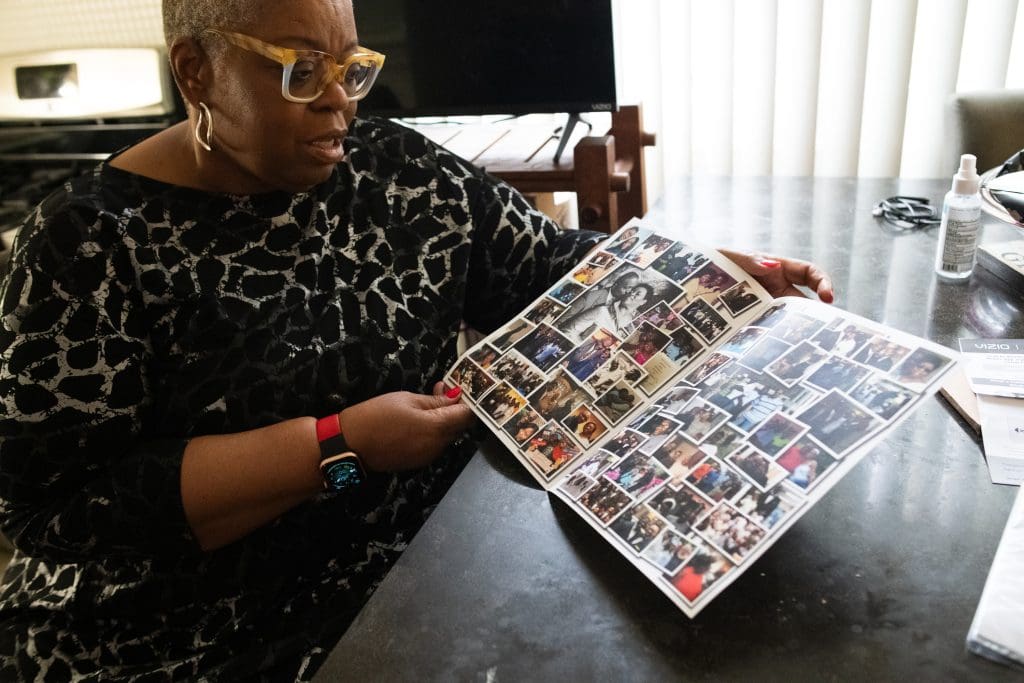 Donna Hammond, a South Side resident, shows photos from the obituary of her late husband and speaks on her experience with calling 911. Photo by Ash Lane for The TRiiBE®