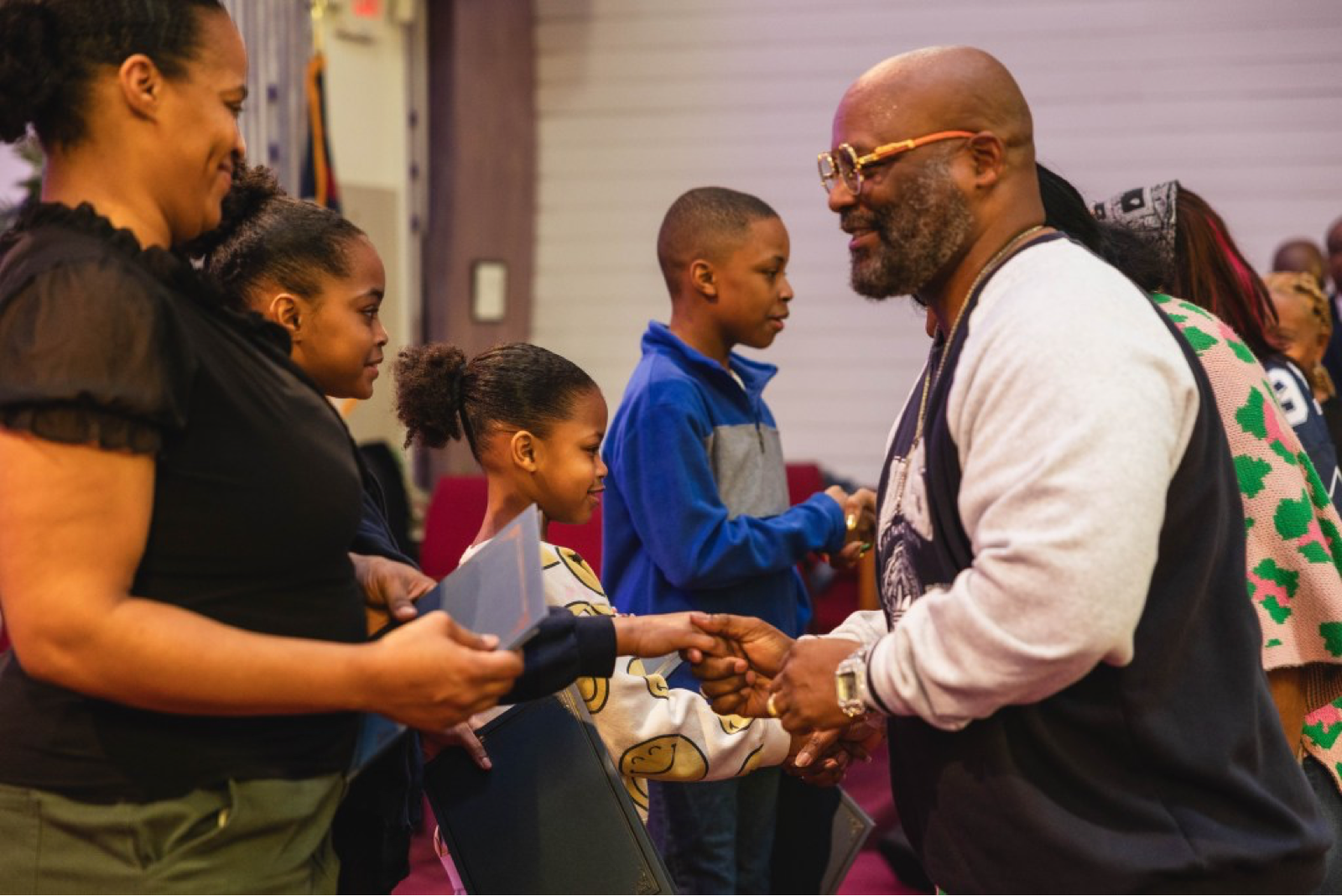 Pastor Rodney Goss and congregants of Morning Star Baptist Church congratulate and welcome a group of children who chose to be baptized. They were presented with certificates and given a church wide welcome. Credit: Molly McElwain / Tulsa Flyer.