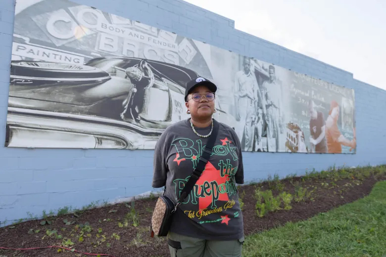 Artist Jen Everett stands in front of the mural she created honoring the 80 year legacy of Collier Brothers Auto Body during the Common Ground Community Car Show & Block Party at 4561 Delmar Blvd. Lawrence Bryant | St. Louis American