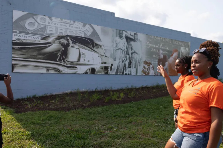 Sydney Jackson speaks in front of a mural honoring the 80 year legacy of Collier Brothers Auto Body during the Common Ground Community Car Show & Block Party on Delmar Boulevard. Lawrence Bryant | St. Louis American