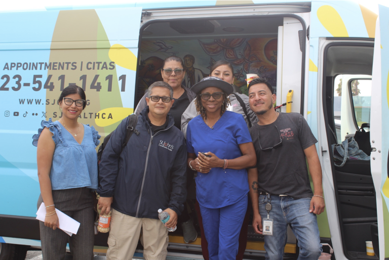 Members of St. John’s street medicine team stand by their mobile clinic van before heading out on outreach in Los Angeles. Photo by Marion Apio