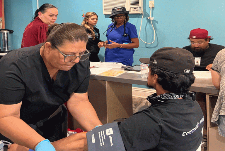 Tanny and Benwell Hernandez receive medication from the street medicine team at their temporary shelter. (Photo by Marion Apio)