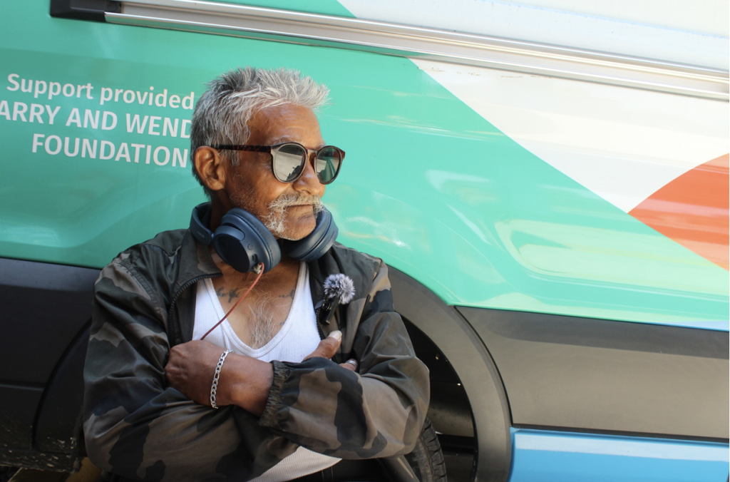 Gilbert Ramirez poses for a photo beside the Venice Family Clinic mobile van after receiving treatment and medication at the Los Angeles Inn in Inglewood. Photo by Marion Apio